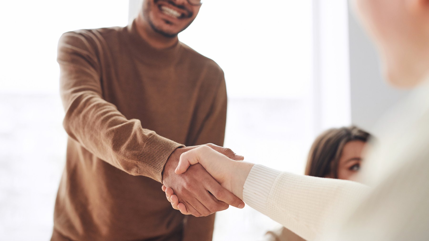 Man shaking woman's hand in the office